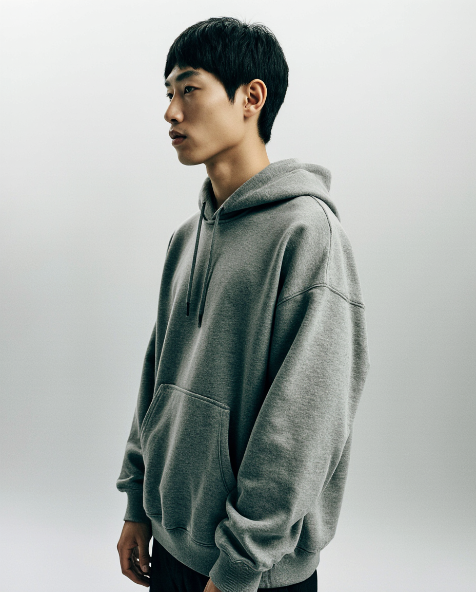 Person wearing a gray hoodie against a plain background